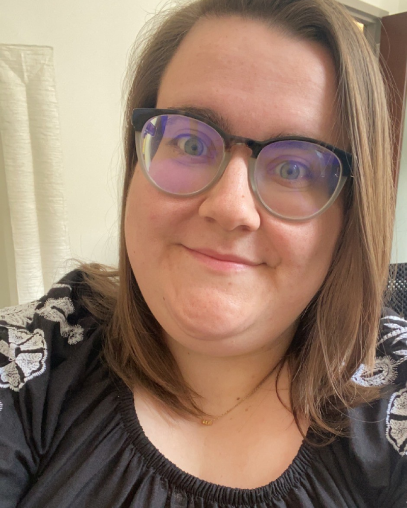 A woman with brown hair and glasses